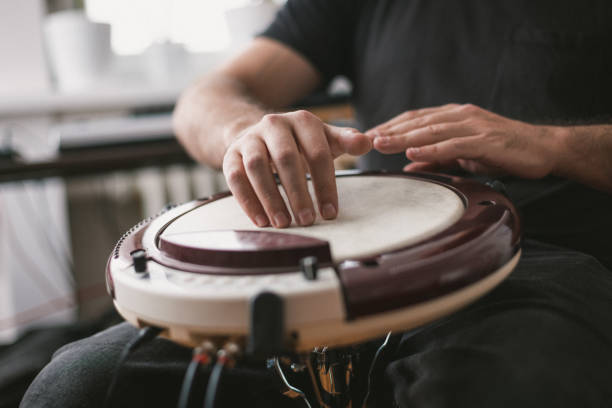 istock Young musician playing wavedrum percussion instrument in home music studio 1439610929