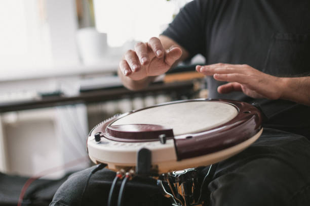 istock Young musician playing wavedrum percussion instrument in home music studio 1439610938