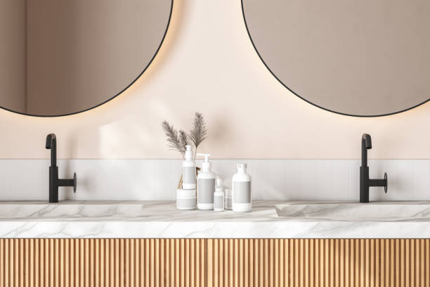 istock 3D rendering close up of a modern vanity unit in the bathroom with round mirrors on double marble basin, white square tiles and beige wall. Morning Sunlight, Products display background, Mock up. 1439614366