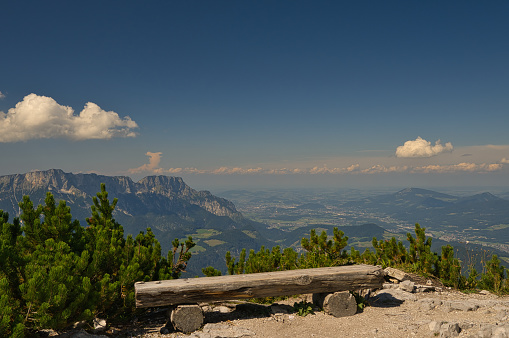 A bench made of wood with a beautiful view of the valley of Berchtesgaden