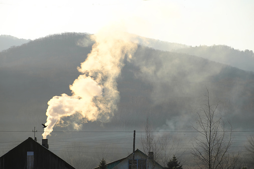Chimneys and cooling towers from a coal fired power station releasing smoke and steam into the atmosphere. The power plant is also releasing CO2 which contributes to global warming and climate change.