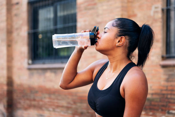 istock sportswoman drinking water during a workout 1439626601