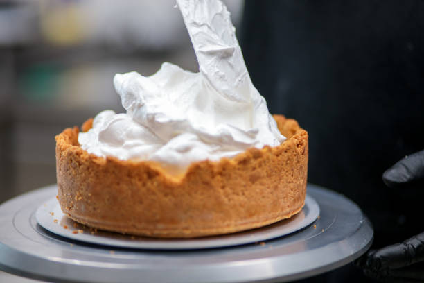 istock pastry chef designer filling a pie crust with lime flavour meringue with spatula 1439626719