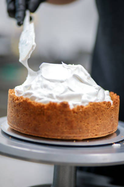 istock pastry chef designer filling a pie crust with lime flavour meringue with spatula 1439626726
