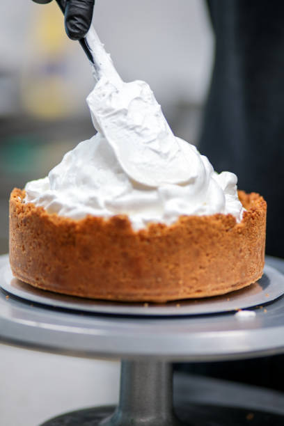 istock pastry chef designer filling a pie crust with lime flavour meringue with spatula 1439626727