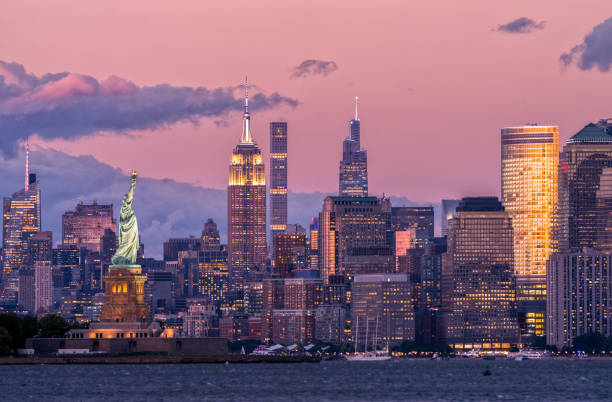 new york city skyline and statue of liberty at dusk - midtown-manhattan imagens e fotografias de stock