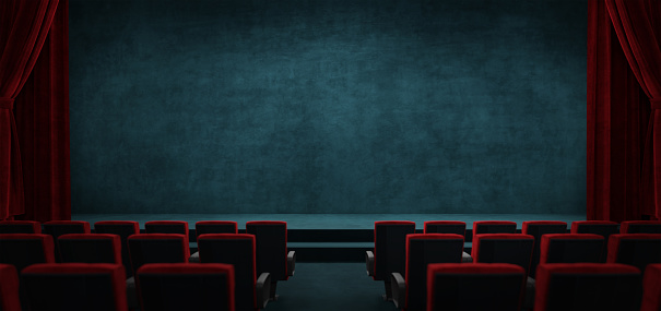 Empty big movie theater hall with a white screen for copy space. Wide angle view of the purple seats and the room, looking at the screen.