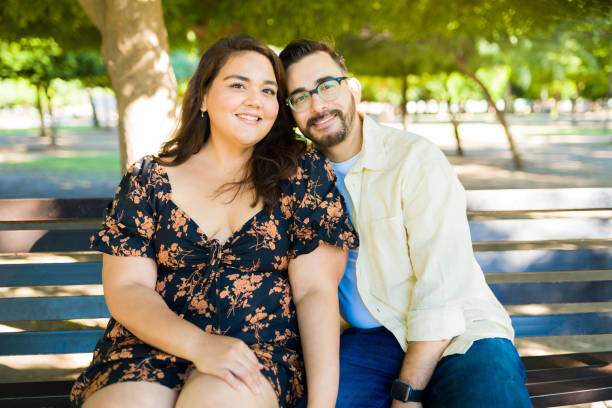 istock Smiling couple dating while sitting at the park 1439643880