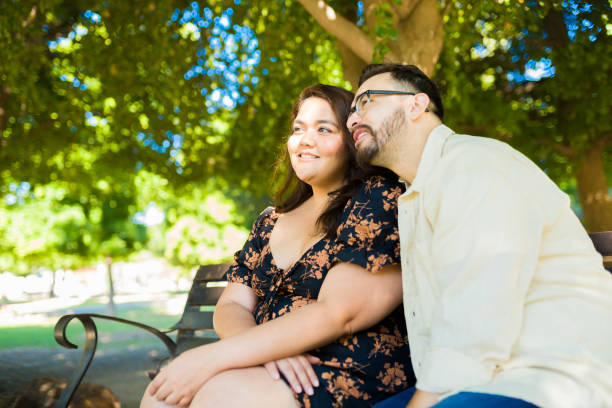 istock Couple in love hugging at the park bench 1439643899