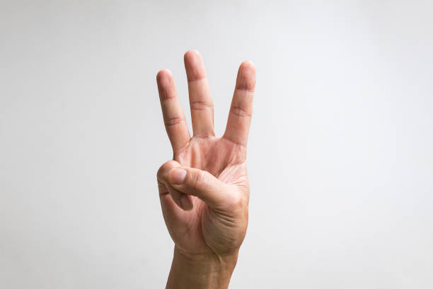 Pointing up with fingers number three. Pointing up with fingers number three. Close up, isolated on white background. finger stock pictures, royalty-free photos & images