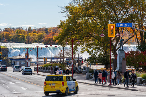 Niagara Falls City, Ontario, Canada - October 27 2022 : Crossroad of Clifton Hill and Falls Ave in autumn foliage season. American Falls in the background.