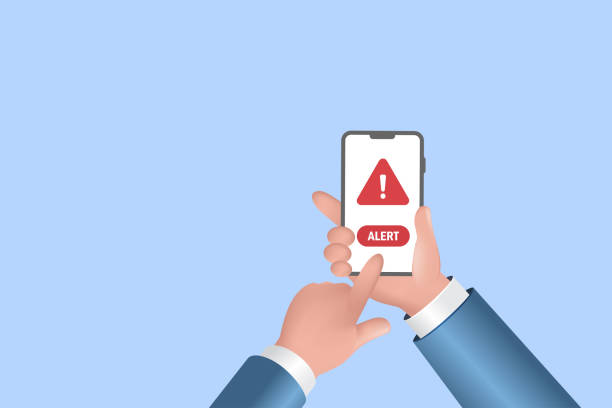 istock Businessman hand holding smartphone with malware alert warning sign. Online scam alert, cyber attack, 3D realistic vector. 1439651518