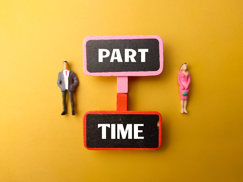 Wooden board and miniature people with text PART TIME on a yellow background.