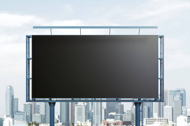 istock Blank black horizontal billboard on skyline background, front view. Mock up, advertising concept 1439667143