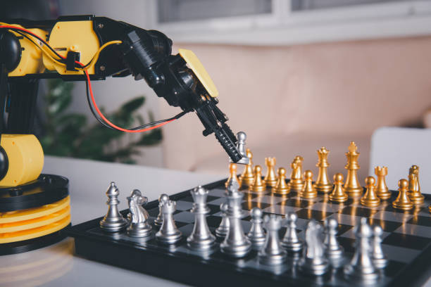 istock Closeup yellow robot arm playing move chess on chessboard 1439668603