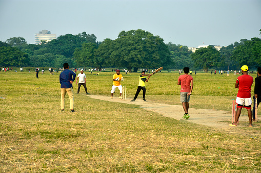 Kolkata, west Bengal,India 11.06.2022 The crazy Indian young cricket supporters playing cricket in the city Ground in front of Victoria Memorial remembering the ICC cricket world cup held in Australia now a days.