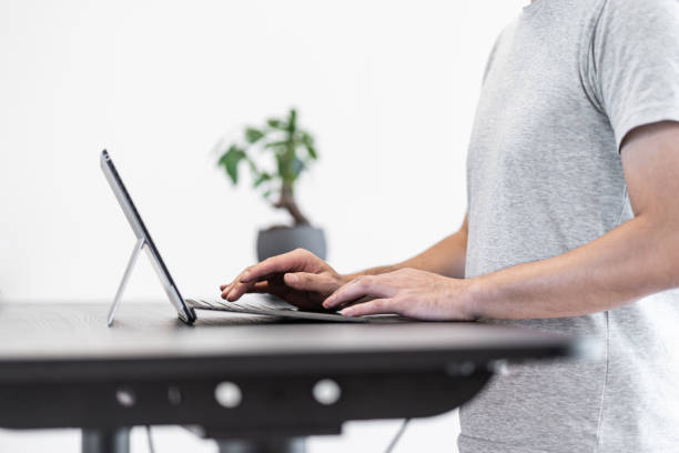 Asian man working at standing desk stock photo