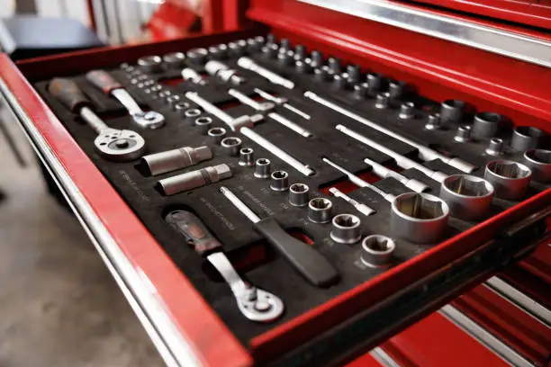 Photo of car service tools in tray of the red steel suitcase. Mechanic, equipment in garage Concept.