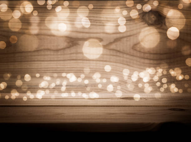 istock Dark abstract background with defocused lights
and wooden table 1439676475