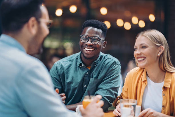 Young friends enjoying drinks together stock photo