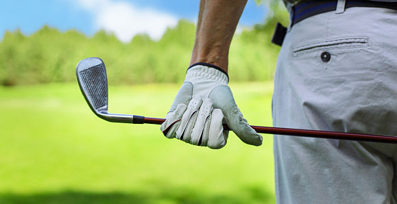 Back view of a male golf player at the green course