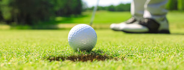 istock Golf player at the putting green hitting ball into a hole. 1439677538