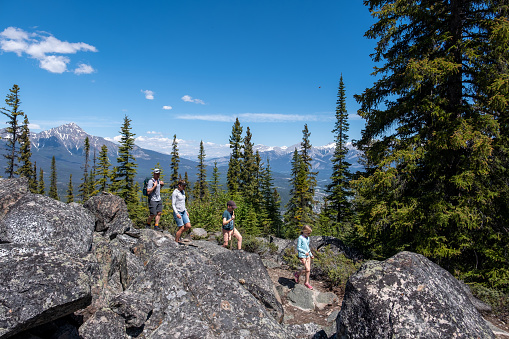 A family enjoy hiking the trails in the Jasper National Park in Canada. Outdoor activities when travelling through Canada in summer.