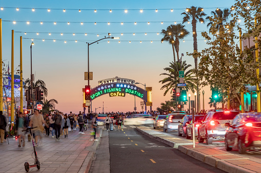 Santa Monica, USA - March 16, 2019: The welcoming arch of Santa Monica Pier in Santa Monica, USA by night. The site is an iconic 100-year-old landmark for California visitors.