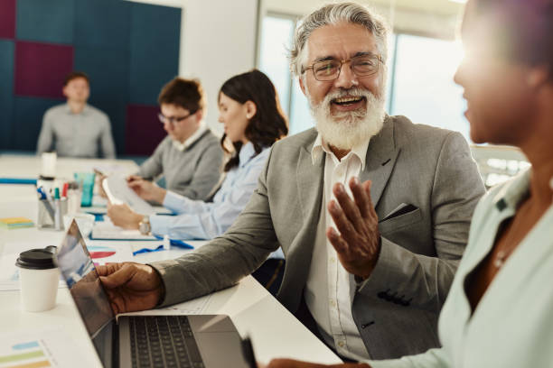 istock Happy business colleagues talking while working on laptop in the office. 1439683550