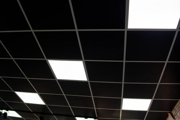 black ceiling with neon light bulbs in uprisen view. Fluorescent light in office interior with dark ceiling black ceiling with neon light bulbs in uprisen view. Fluorescent light in office interior with dark ceiling. ceiling tile lighting stock pictures, royalty-free photos & images
