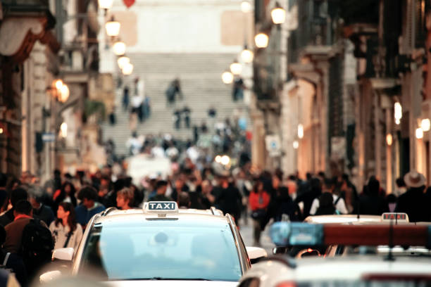 Taxi driving through people and traffic in downtown Rome, Italy stock photo