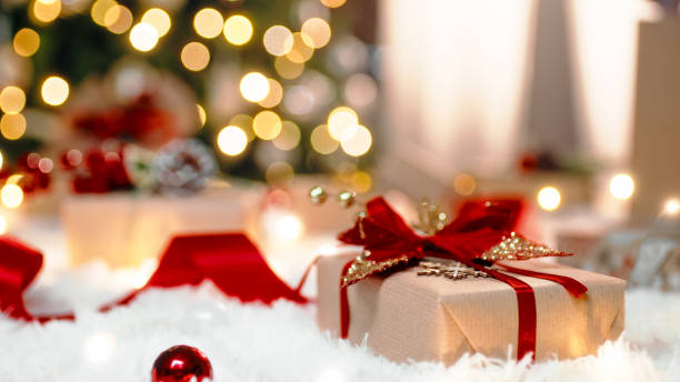 Christmas gif box on the white carpet against the tree