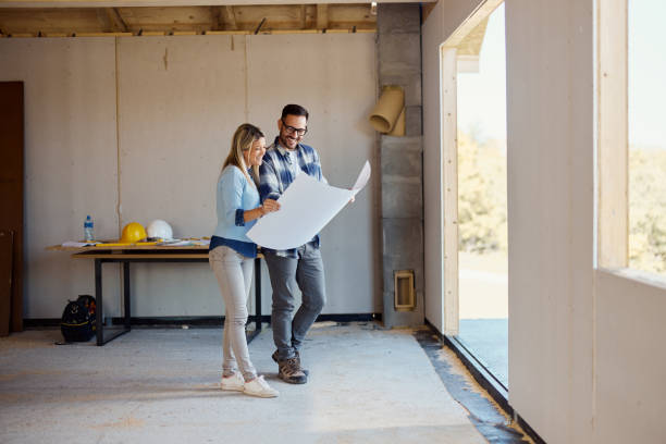 istock Happy couple reading blueprints of their developing house. 1439686034