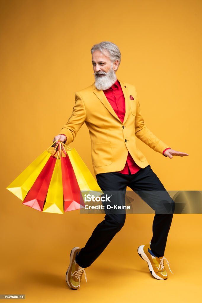 Happy well dressed gentleman having photoshooting in studio Portrait of a man wearing yellow jacket on yellow background. Styled, well dressed man. Shopping Stock Photo
