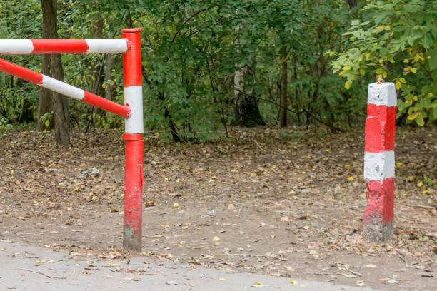 istock An iron barrier in a forest, painted in red and white stripes, a checkpoint. 1439688049