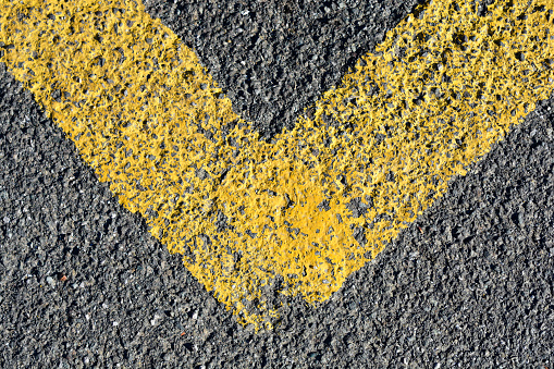 Detail of an asphalt road with yellow painted line