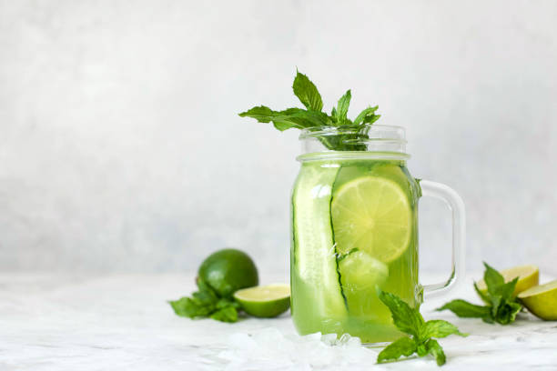 istock Lemonade with cucumber and lime and mint leaves on a gray background. 1439690404