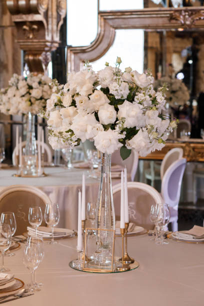 istock Tables setting at a luxury wedding. Table for guests. Dishes and drinks. Floral decorating, white chairs and table. Wedding table preparation. top view. Horizontal photo 1439690553