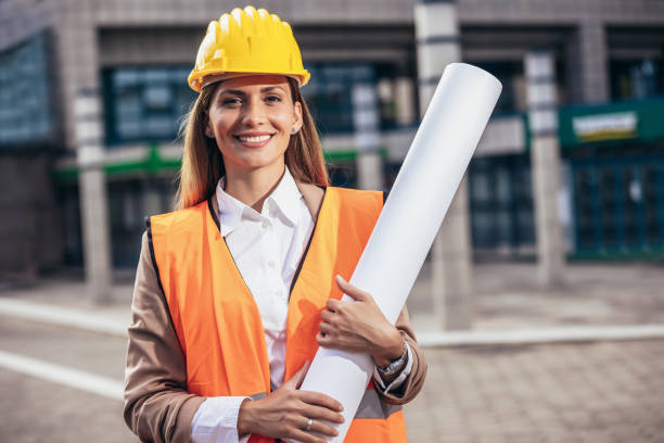 istock Engineer woman in safety equipment  holding plans. Building, developing, construction and architecture concept. 1439691451