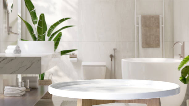 mesa auxiliar redonda blanca en baño de diseño moderno y de lujo y plátano tropical con luz solar moteada desde la ventana y sombra de hojas en la pared de baldosas de granito blanco - bathroom bathroom sink sink design fotografías e imágenes de stock