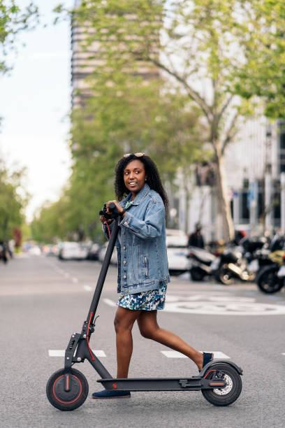 femme africaine heureuse avec scooter électrique - love smiling human settlement viewpoint photos et images de collection