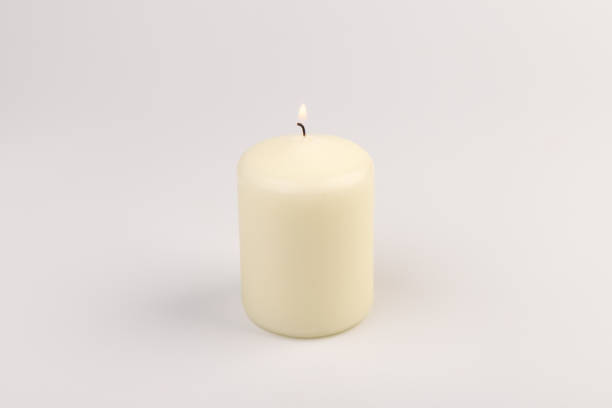 istock Burning white wax candles on white background. 1439694691