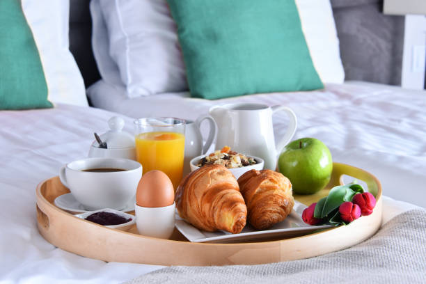 istock Breakfast on tray in bed in hotel room 1439695610