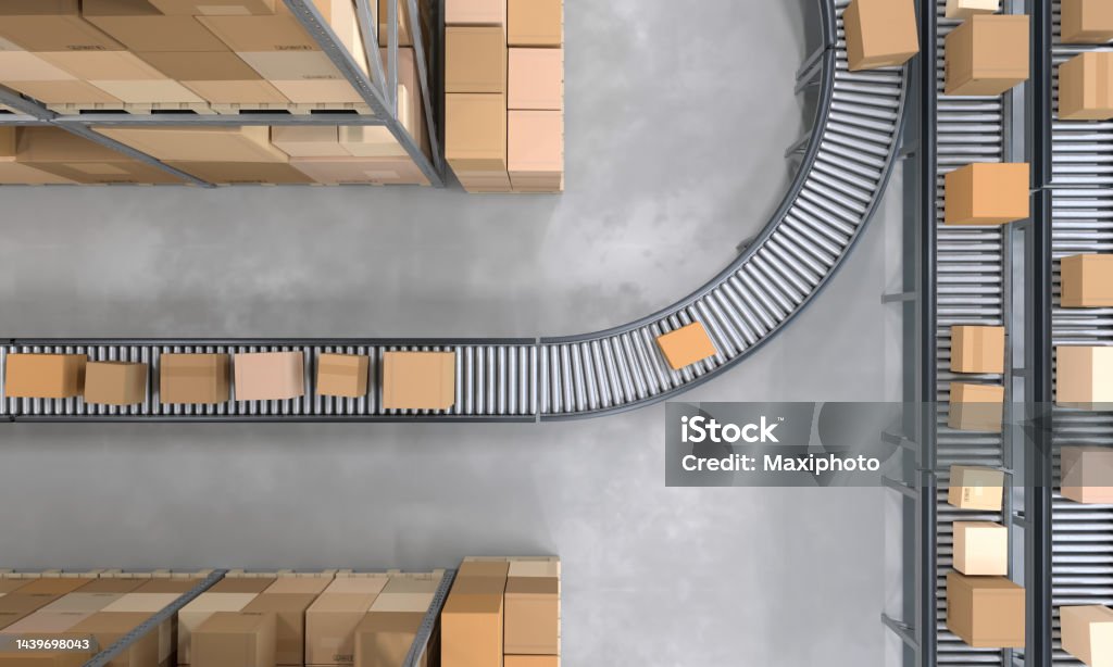 Top view of conveyor belts transporting boxes in a large warehouse Top view of conveyor belts transporting boxes ready to be shipped in a large distribution warehouse full of merchandise . Organization and efficiency. Digitally generated image. Conveyor Belt Stock Photo