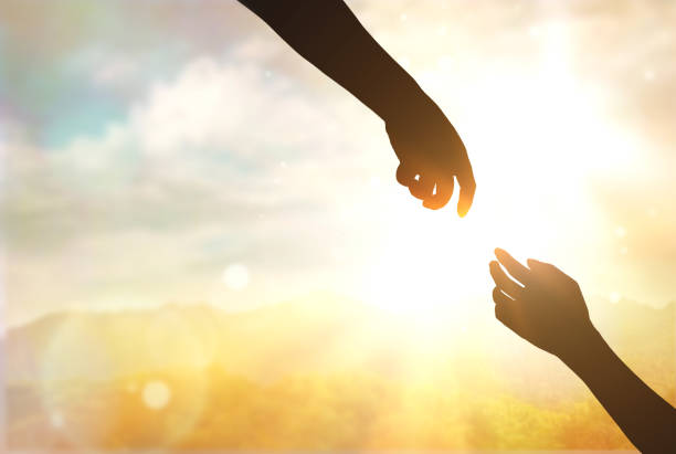 istock silhouette of two hands on sunset background, help concept, hope and mutual support 1439698364