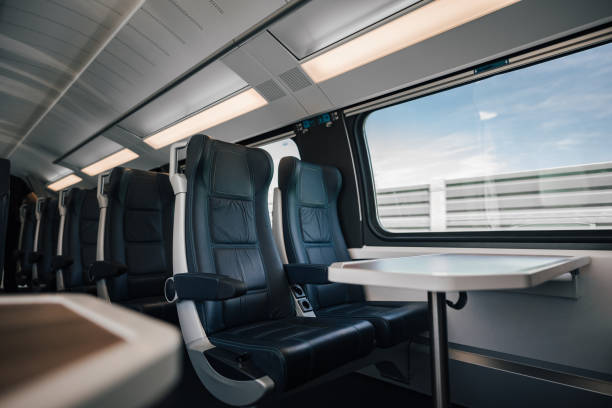istock Table and empty leather seats by window in modern illuminated passenger train 1439699222