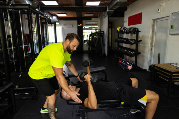 istock Personal trainer and man at the gym 1439701709