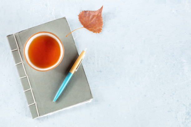 istock A diary. A paper journal with a pen, an autumn leaf, and a cup of tea 1439703379