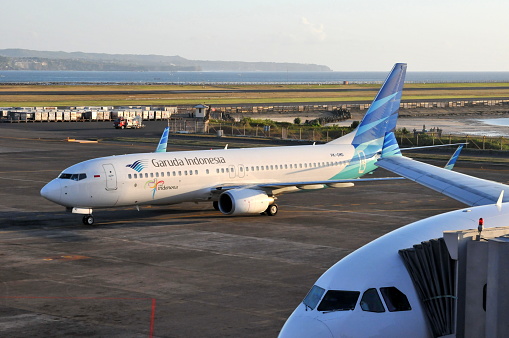 Bali, Indonesia-August 3, 2011: Bali is a charming vacation destination in South East Asia. Its uqique culture elements and diverse landscapes attracts tourists all over the World.  Here is the a Boeing 737 airplance of Garuda Indonesia Airlines in Bali Denpasar International Airport.