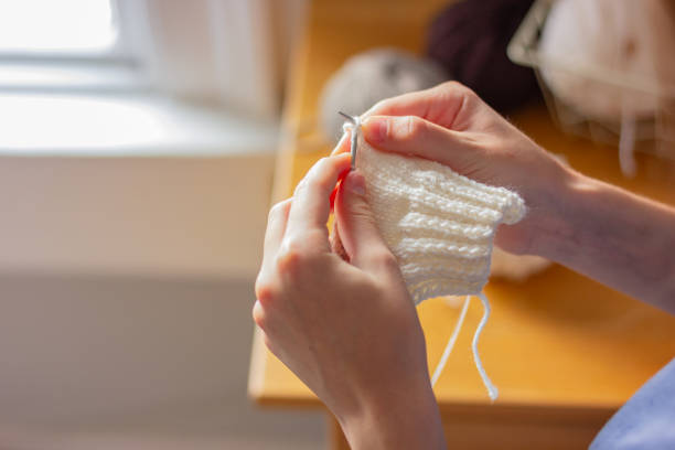 istock close-up of hands knitting things from white yarn 1439704768